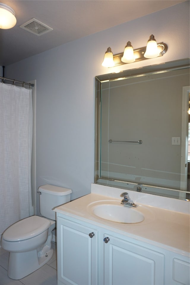 bathroom with vanity, tile patterned flooring, toilet, and curtained shower