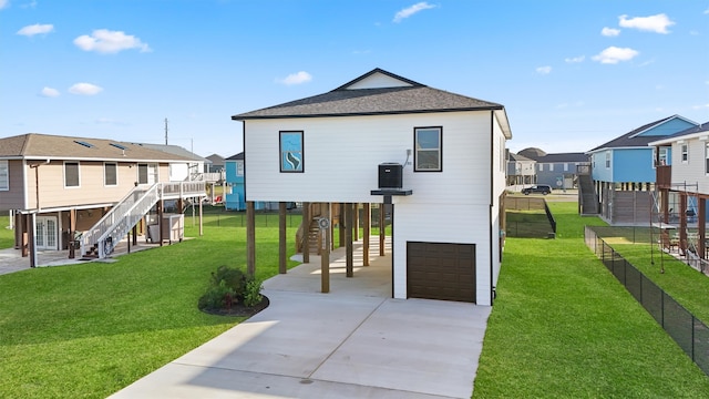 rear view of house featuring a yard and a garage