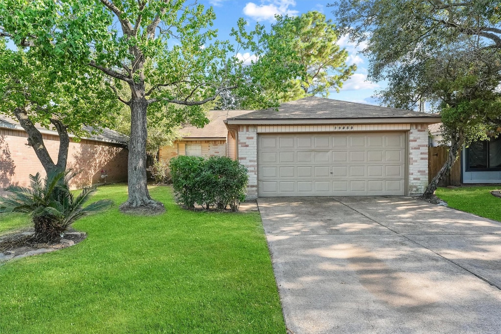 ranch-style house featuring a front yard, brick siding, and driveway