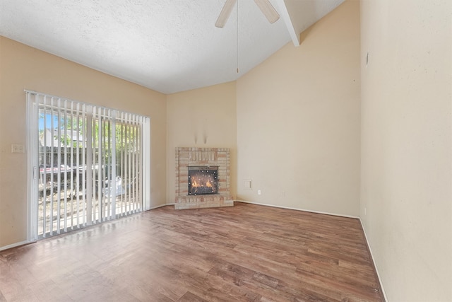 unfurnished living room featuring lofted ceiling, hardwood / wood-style floors, ceiling fan, and a brick fireplace