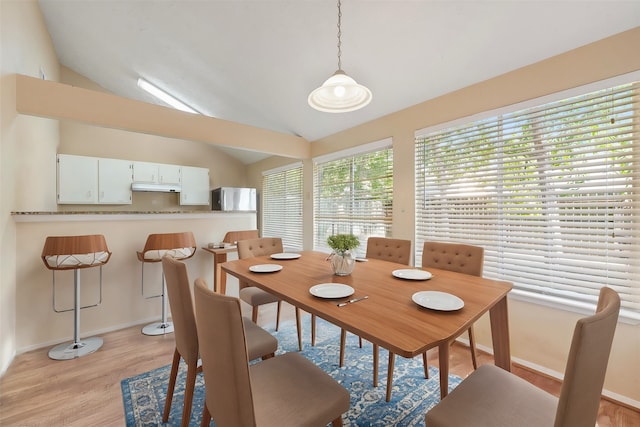 dining area featuring light wood-type flooring and lofted ceiling