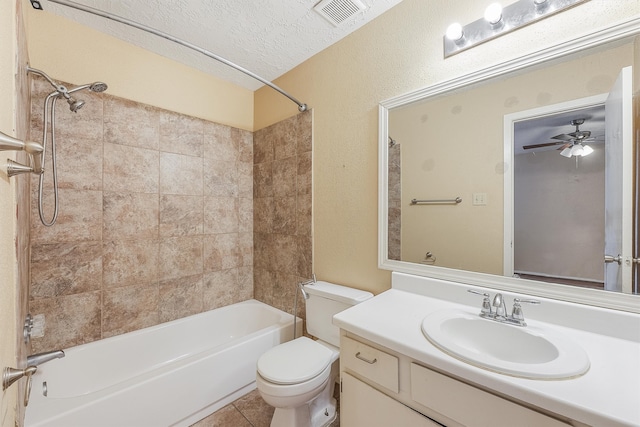 full bathroom with toilet, vanity, a textured ceiling, tiled shower / bath combo, and ceiling fan