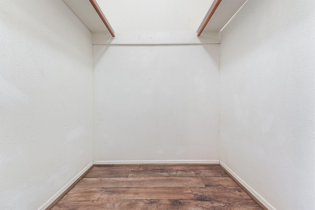 walk in closet with dark hardwood / wood-style flooring