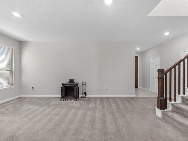 unfurnished living room with light carpet and a textured ceiling