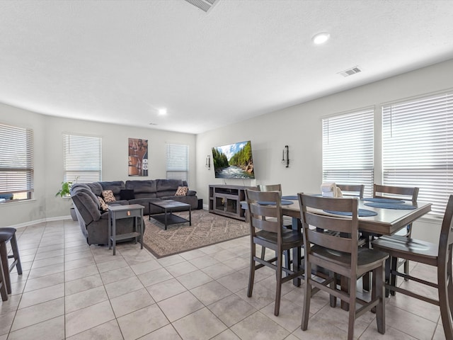 dining area featuring a textured ceiling, plenty of natural light, and light tile patterned flooring