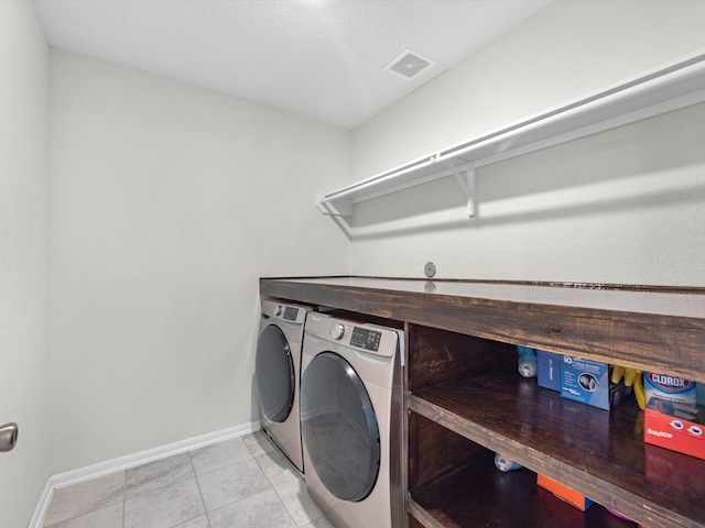 washroom with light tile patterned floors and washing machine and clothes dryer