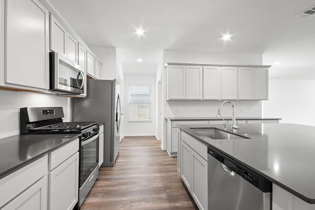 kitchen featuring stainless steel appliances, white cabinets, sink, and dark hardwood / wood-style flooring