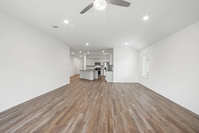 unfurnished living room with light hardwood / wood-style floors, ceiling fan, and vaulted ceiling