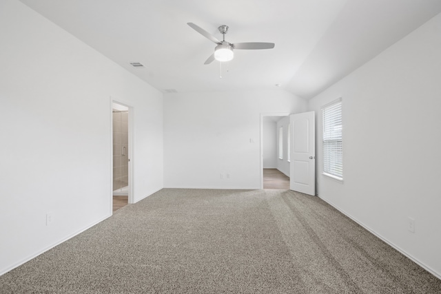 carpeted spare room featuring ceiling fan and lofted ceiling