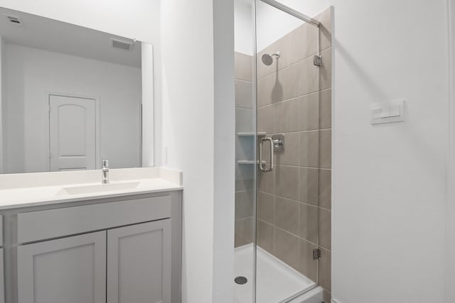 bathroom featuring vanity and a shower with door