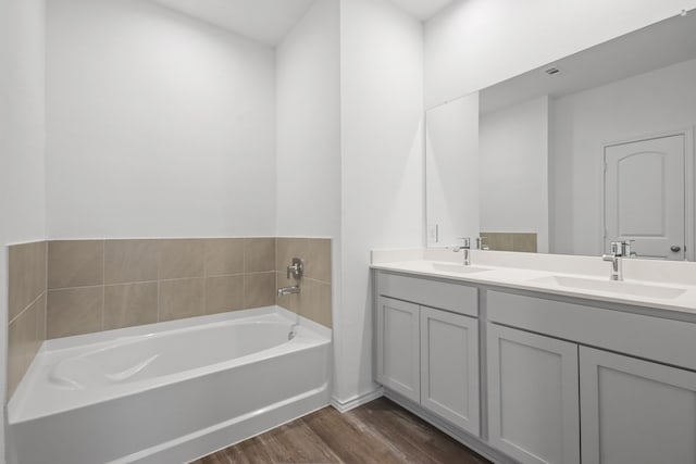 bathroom featuring hardwood / wood-style floors, vanity, and a tub to relax in