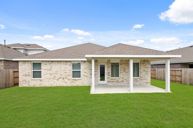 back of property with a lawn and a patio