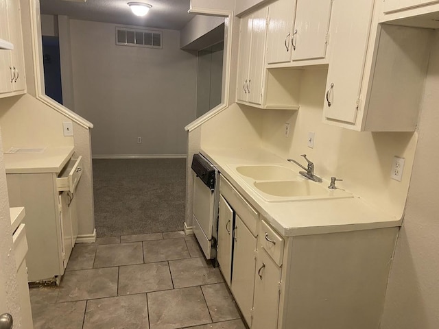 5669 Birchmont Dr Unit A, Houston, TX 77091 - kitchen featuring a sink, white dishwasher, white cabinets, light countertops, and tile patterned flooring