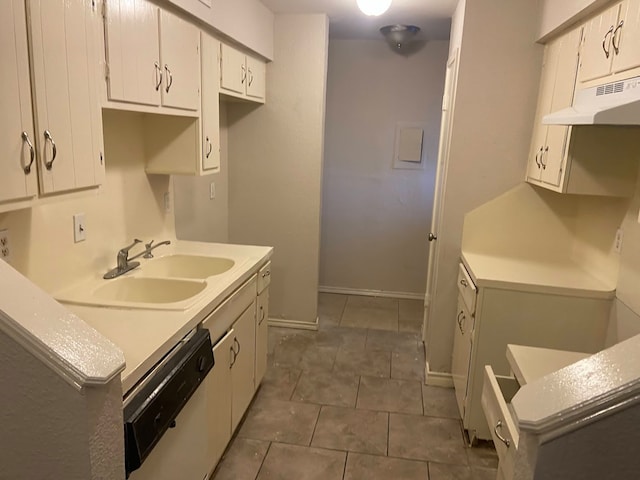 kitchen with dark tile patterned flooring, dishwasher, white cabinetry, and sink