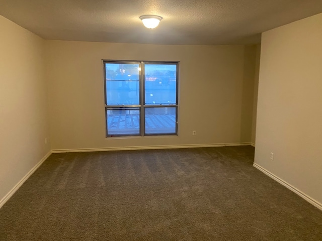 carpeted empty room featuring a textured ceiling