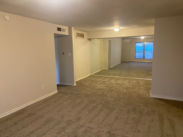 spare room with dark carpet