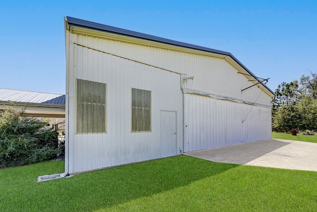 view of side of home with an outdoor structure and a lawn