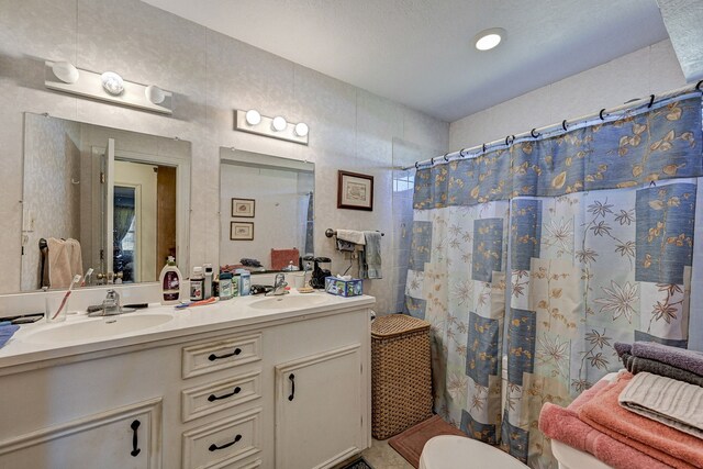 bathroom featuring vanity, toilet, a shower with curtain, and a textured ceiling