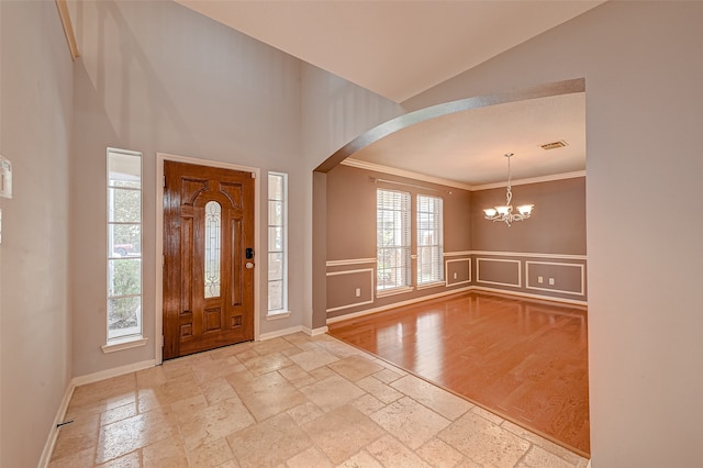 foyer featuring ornamental molding, light hardwood / wood-style flooring, and an inviting chandelier