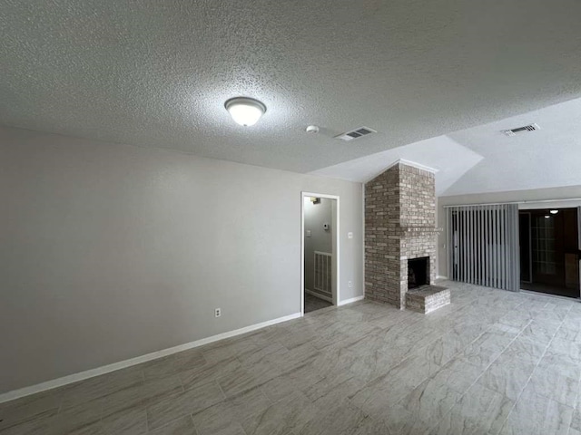 unfurnished living room featuring lofted ceiling, a brick fireplace, and a textured ceiling