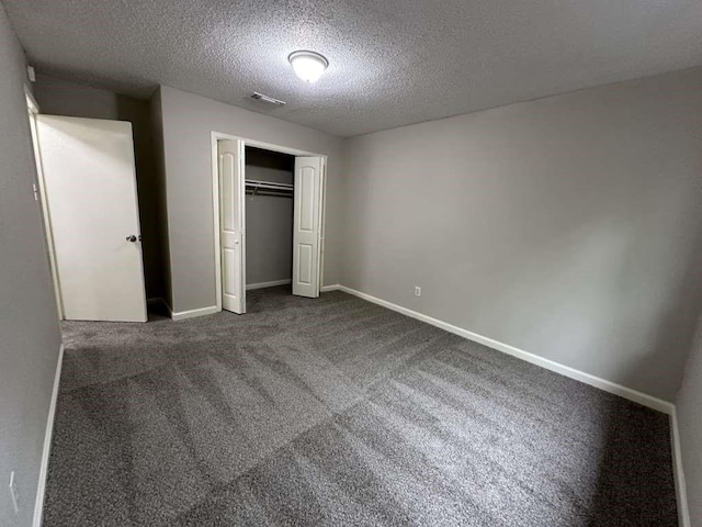 11807 S Youngwood Ln, Houston, TX 77043 - unfurnished bedroom with a textured ceiling, carpet floors, a closet, and baseboards