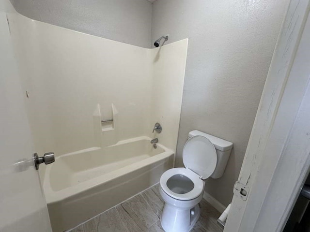 bathroom with toilet, hardwood / wood-style flooring, and shower / tub combination