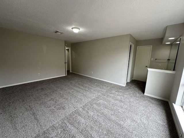 carpeted empty room featuring a textured ceiling