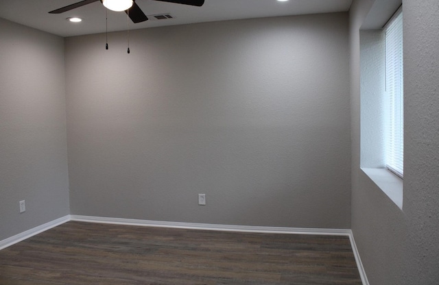 empty room with dark wood-type flooring and ceiling fan