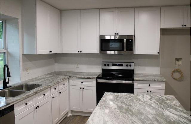 kitchen with dark hardwood / wood-style flooring, sink, appliances with stainless steel finishes, and white cabinetry