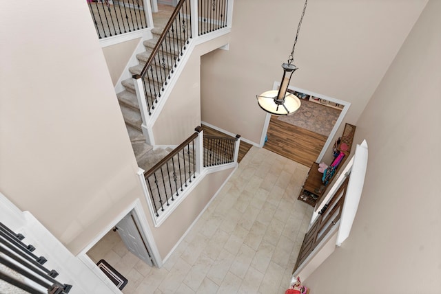 stairs featuring tile patterned flooring and a towering ceiling