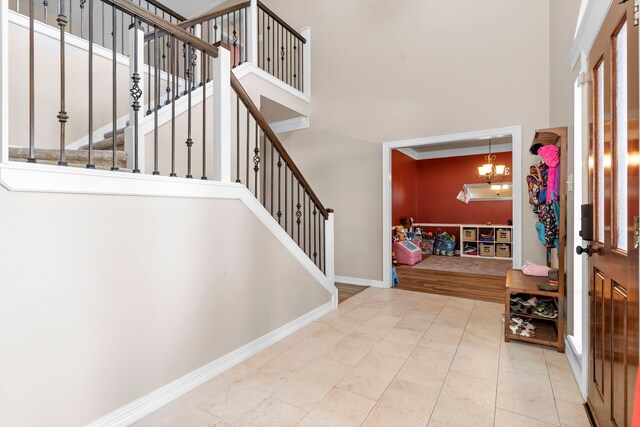 entryway with a chandelier, crown molding, and a towering ceiling