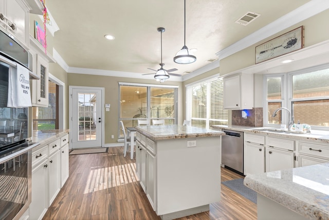 kitchen featuring white cabinets, pendant lighting, a center island, and stainless steel appliances