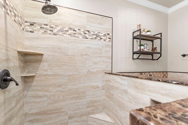 bathroom with crown molding and a tile shower