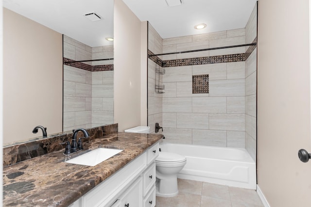 full bathroom featuring tile patterned flooring, toilet, tiled shower / bath combo, and vanity