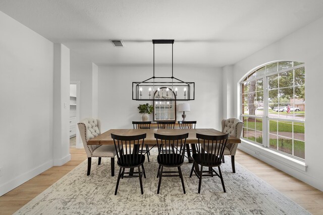 dining space with plenty of natural light, light wood-type flooring, and a chandelier