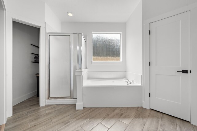 bathroom featuring hardwood / wood-style floors and independent shower and bath