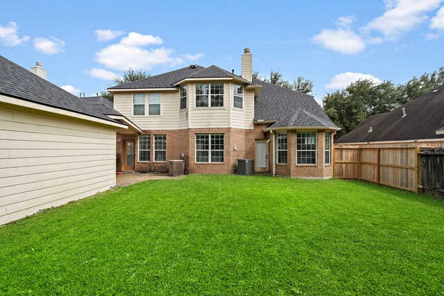 back of house featuring a patio area, a lawn, and central AC unit