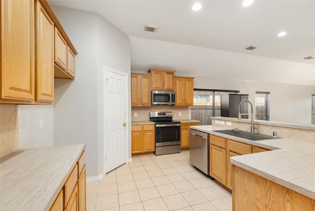 kitchen featuring light tile patterned floors, stainless steel appliances, decorative backsplash, and sink