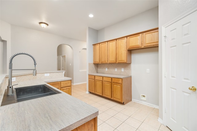 kitchen with light tile patterned floors, backsplash, and sink