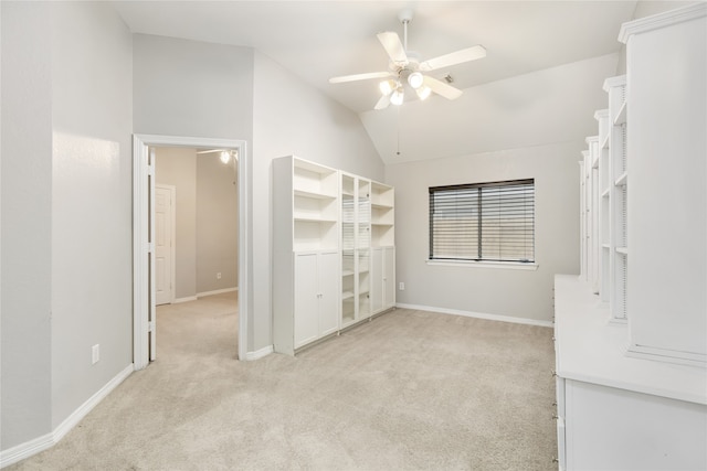 interior space with lofted ceiling, ceiling fan, and light carpet