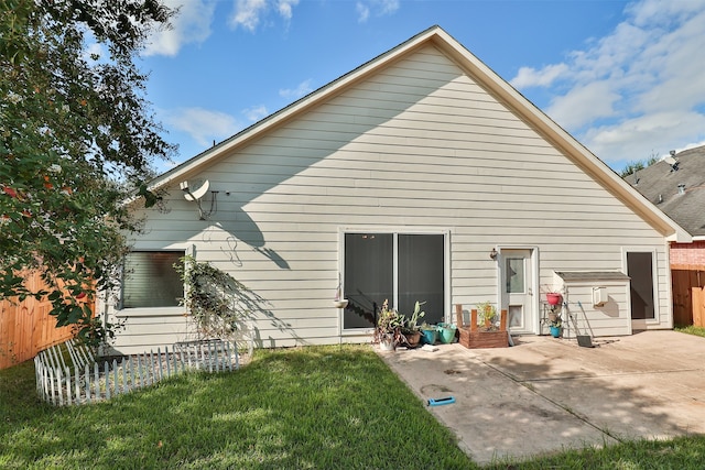 back of property featuring a lawn and a patio area