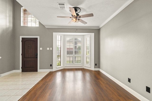 entryway featuring light wood-type flooring, a wealth of natural light, and crown molding