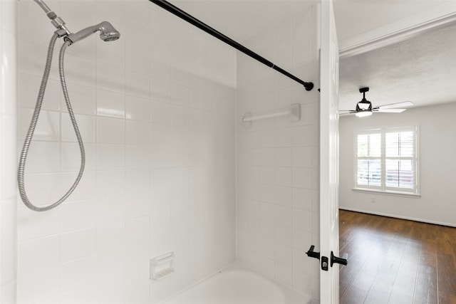 bathroom with hardwood / wood-style floors, tiled shower / bath, and ceiling fan