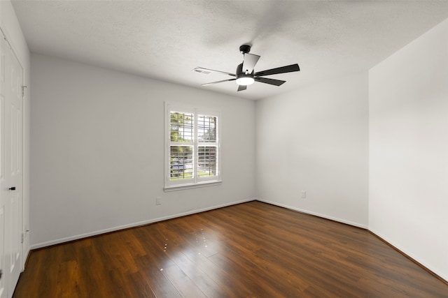 empty room with ceiling fan, a textured ceiling, and dark hardwood / wood-style flooring