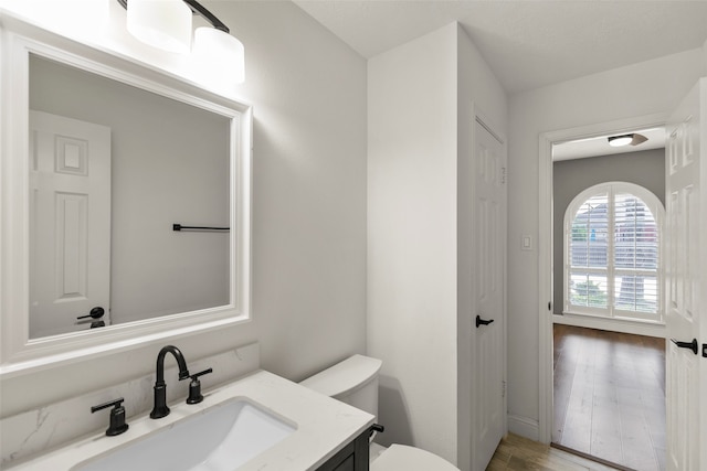 bathroom featuring hardwood / wood-style floors, vanity, and toilet