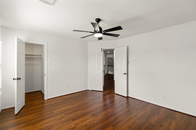 unfurnished bedroom featuring a closet, a textured ceiling, ceiling fan, and dark hardwood / wood-style floors