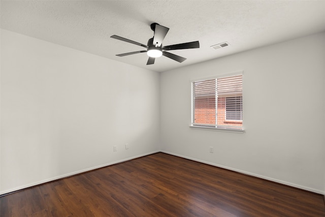 spare room featuring dark hardwood / wood-style flooring, a textured ceiling, and ceiling fan