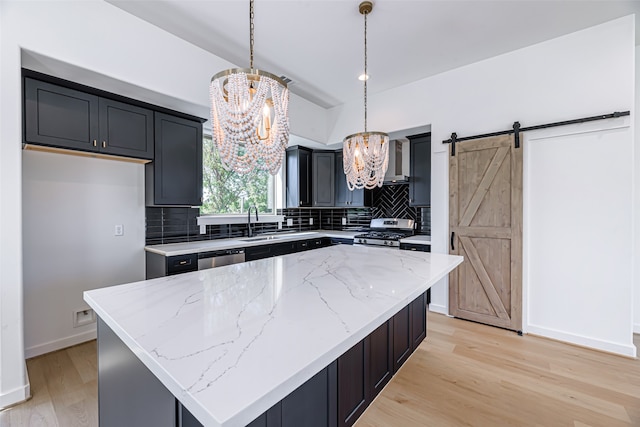 kitchen featuring decorative light fixtures, a barn door, a chandelier, and a kitchen island