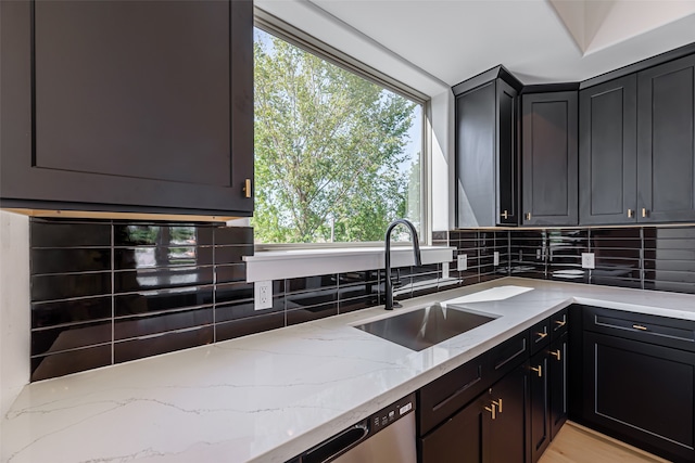 kitchen with sink, light hardwood / wood-style flooring, light stone counters, and tasteful backsplash