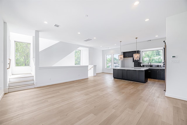 kitchen featuring sink, hanging light fixtures, light hardwood / wood-style floors, and a center island